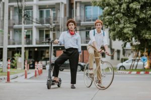 Couples striking a pose with their expensive scooter in front of their school. This couple spent their money wisely on the best product.