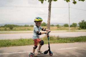 Child riding scooter outside