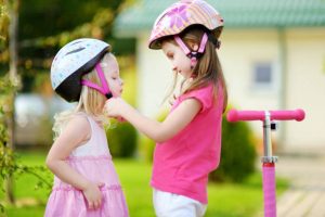 little children who are siblings staying safe by wearing helmets