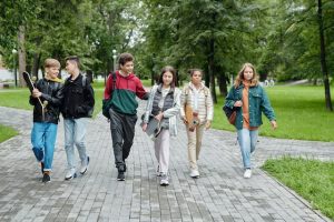 A group of teenagers walking with a skateboard by their side, ready for a skateboarding adventure.