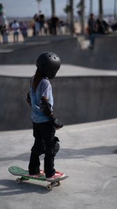 A kid wearing a skateboard helmet. 