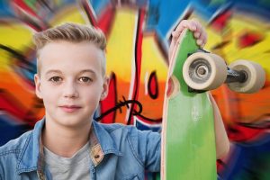 Skateboard Accessories: A young skateboarder holding a green skateboard, representing the accessories to buy in our skateboard buying guide.