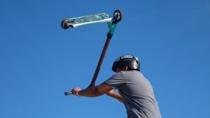 In a confident pose, a boy skillfully holds his scooter facing backward, showcasing his adventurous spirit.