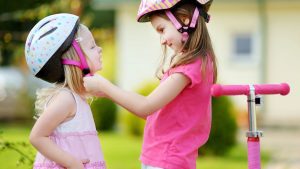 two cheerful children are helping each other put on their suits, eagerly preparing for their ride