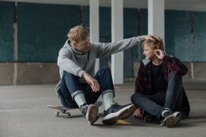 Skaters sitting on their skateboard after skateboarding.