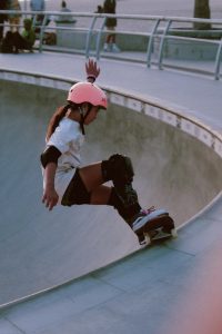A young female does tricks confidently using her board.