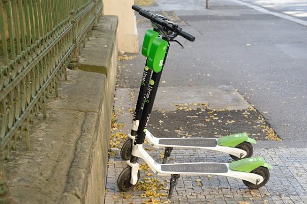 A newly charged electric scooters are parked on the side of the road ready for scooter ride. 
