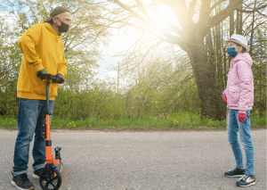 Father teaching his son the importance of gloves for scooters. 