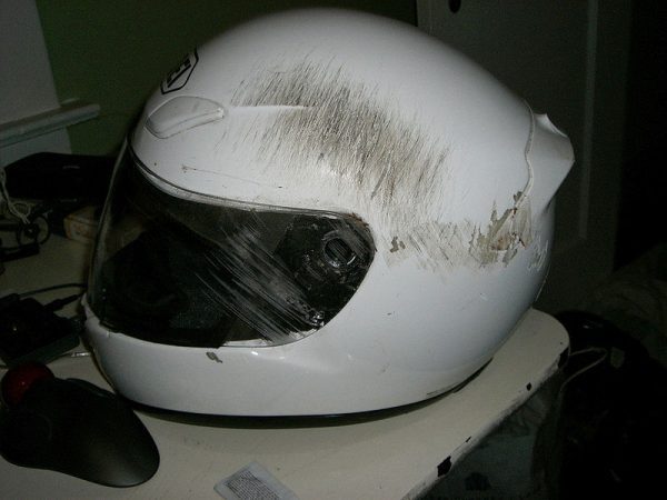 A white helmet with scratches on it due to a severe accident.