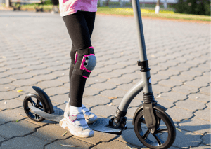 A rider strolled around wearing her knee pads for a scooter. 