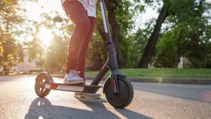 The scooter is ridden in a park, creating a pleasant scene.