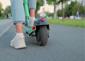 Close shot of a person riding a scooter.