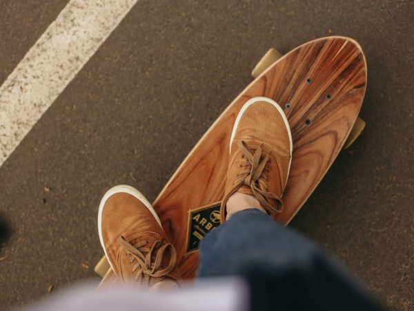 A skater on his skateboard on the street with shoes on for skateboarding