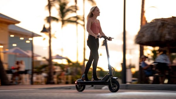 Scooter beach - A girl riding her scooter through a beach town