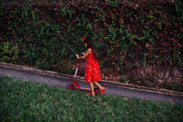 A child pushing a scooter