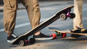 A man's feet firmly grip his longboard for a longboarding trick. 