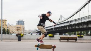 A skateboarder doing his skateboarding and longboarding trick in the skate park.