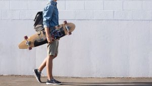 Skateboard & Longboard - A man holding his longboard & ready to skate using his longboard.