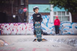 A child skater holding skateboard