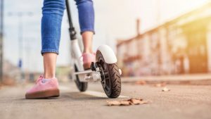 a person is confidently riding a sleek, modern kick scooter designed for balance. The expertly balanced stance on the scooter demonstrates how it's a perfect choice for enhancing balance and stability during scooter rides.