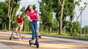 Three joyful ladies riding their choppers at the park with focused enjoyment