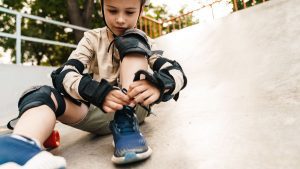 A focused boy prepares to wear his safety suit, ensuring he's equipped with proper gear.