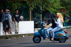 Two girls ride their scooters for fun exploration.