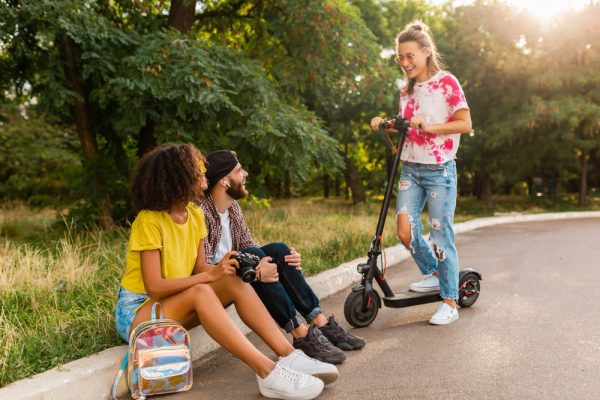 Friends hanging out while sharing their best scooter tricks
