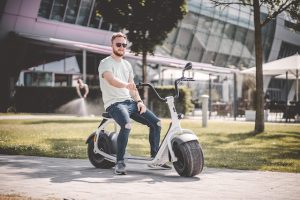 Sitting down on an electric scooter. An electric scooter gives convenience. 