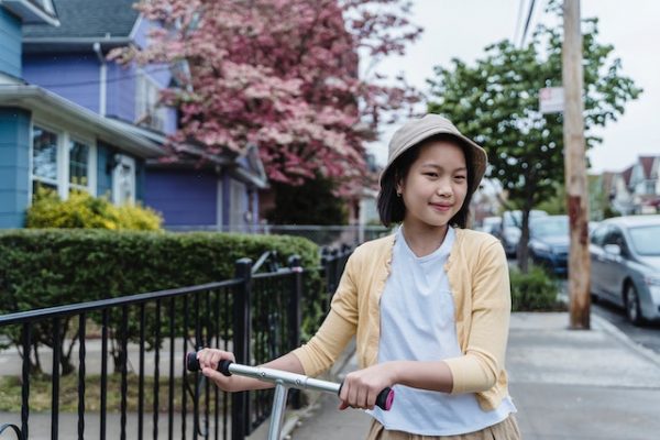 A girl pushing a scooter