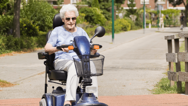 An elder riding a scooter.