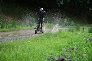 Man with helmet riding along a path in nature.