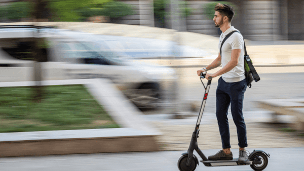 A man riding an e-scooter in high speed. 