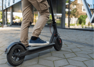 A close up shot of a person using their own scooter.