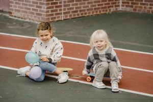 two kids are engaged in joyful and playful activities during their break time. It paints a picture of carefree moments, perhaps outdoors, where children are enjoying themselves