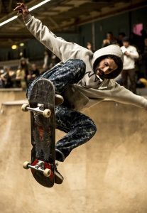 A man is performing skateboarding tricks in skate park.