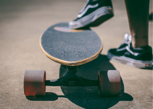 A skater who is about to ride the rusty skateboard. 