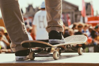 A man on his shoes is ready to do skateboarding tricks in front of the many people.