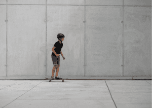 This boy is trying to learn skateboarding by applying skill enhancement tips from skateboard experts. 