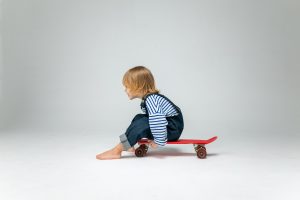 A kid with kid's skateboard ready to learn skateboarding