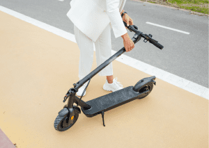 A person wearing all white is folding the scooter. 