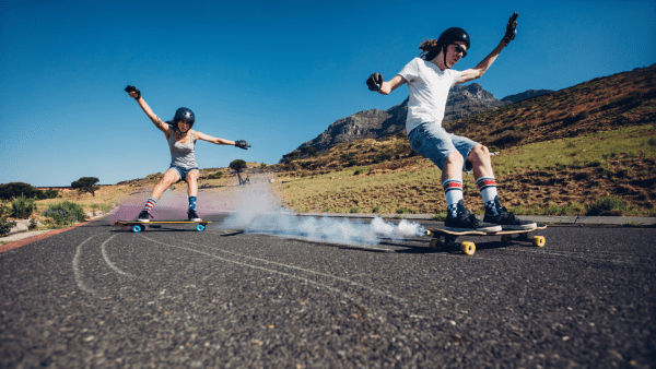 There are two skaters riding their board fast. 