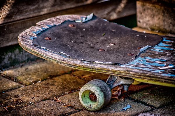 Skateboard. A worn-out skateboard that needs repair. Skateboard that needs cleaning. Skateboard that is rusty. Skateboard is dirty.