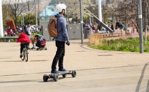 A guy riding his electric skateboard