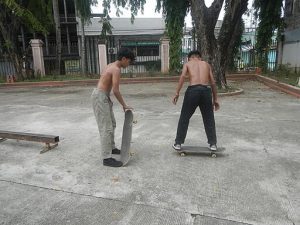 Two shirtless longboarders