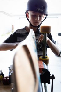 a boy maintaining a skateboard