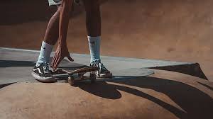 A person reaching his skateboard in the skatepark. 