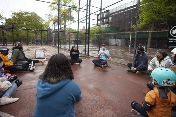 A group of people sitting together in a circle and seem they are having a lesson. 