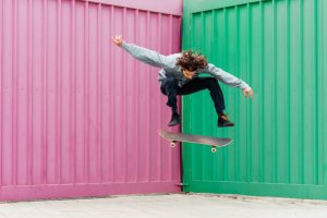 A man wearing long-sleeved shirt does skateboard stunts confidently. 