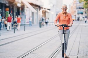 A woman is happily riding her scooter